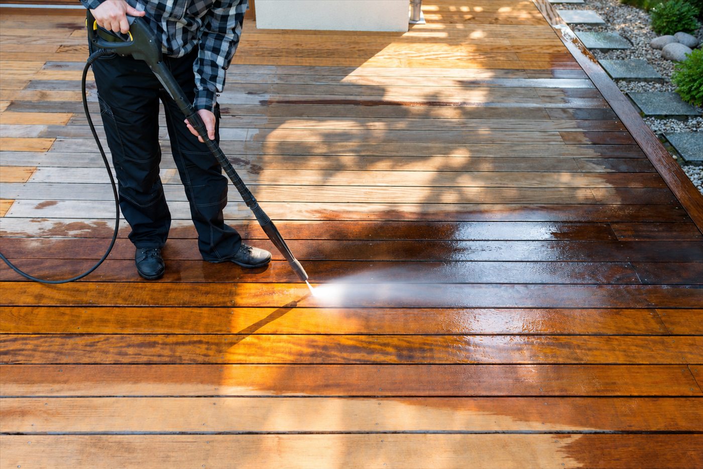 Wood deck being cleaned with a pressure washer