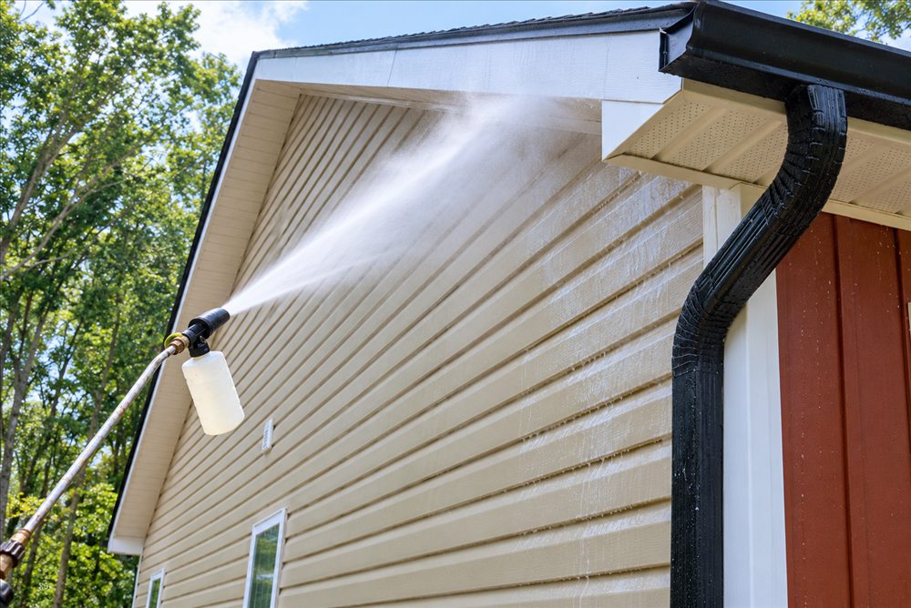 Cleaning solution being applied to vinyl siding at low pressure