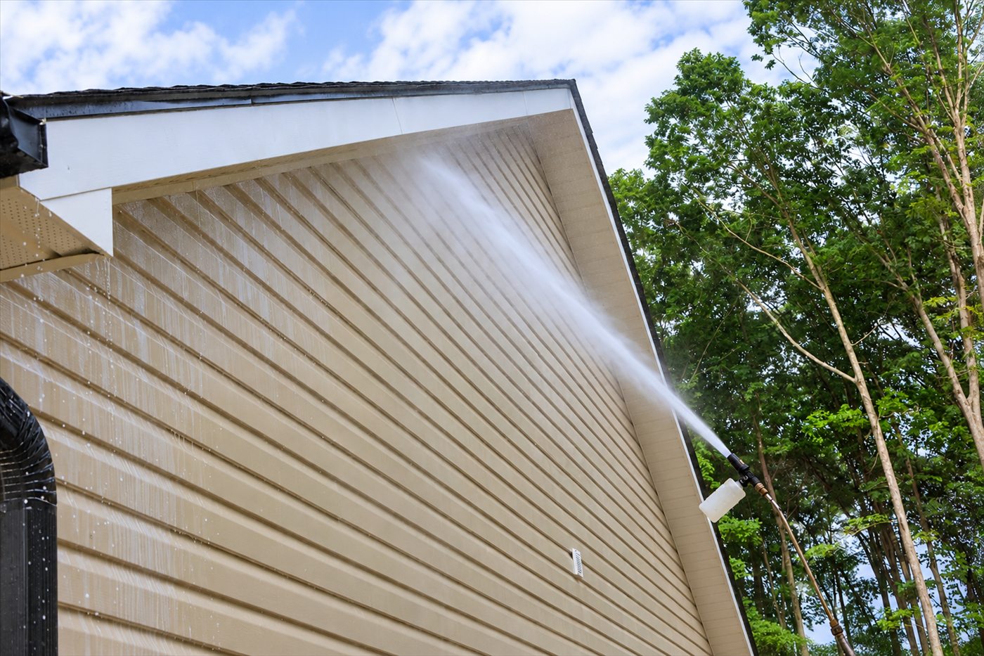 Vinyl siding being washed below the roofline